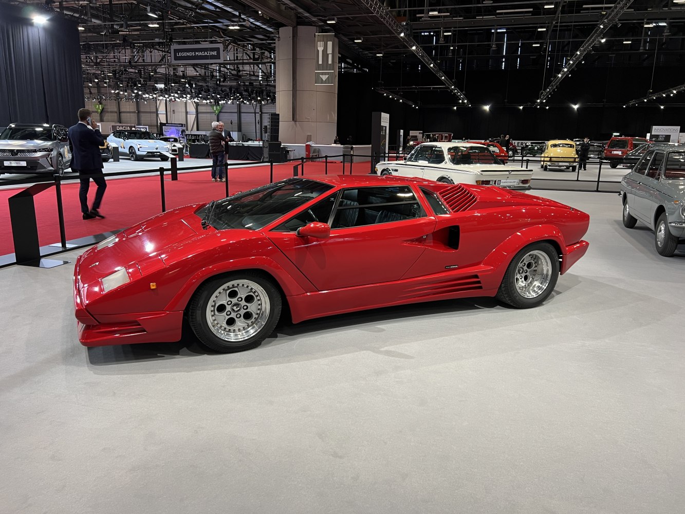 Red classic sports car with pop-up headlights and aero wheels