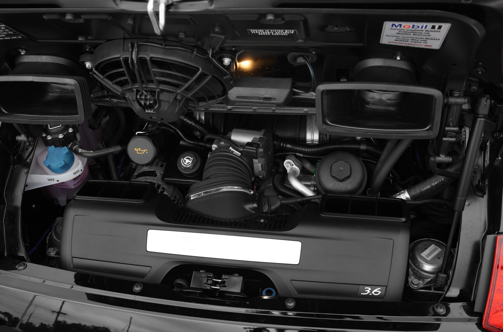 Rear-mounted engine compartment showing 3.6L engine and air intake ducts