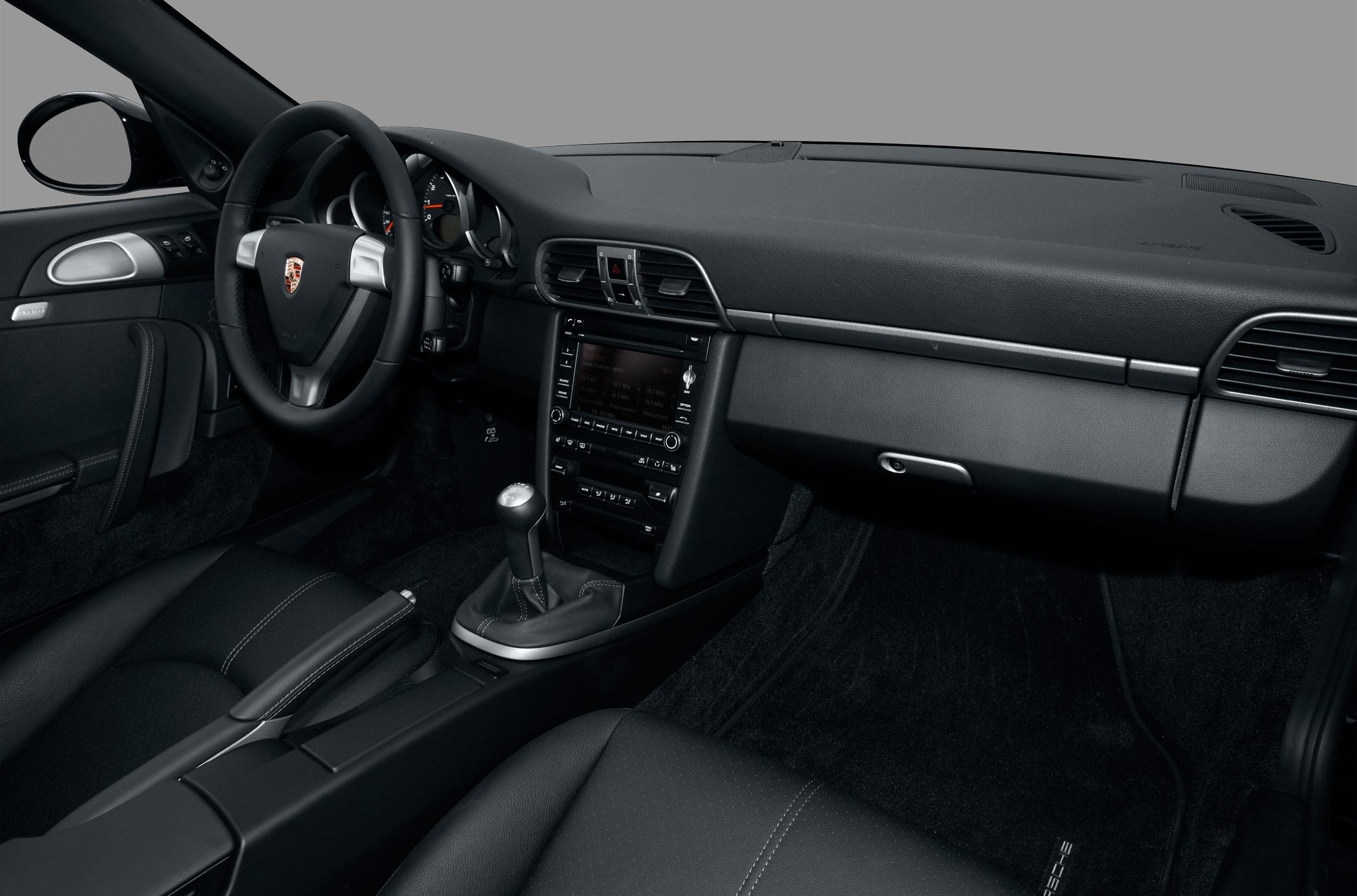Interior with black leather seats and manual gear shifter.