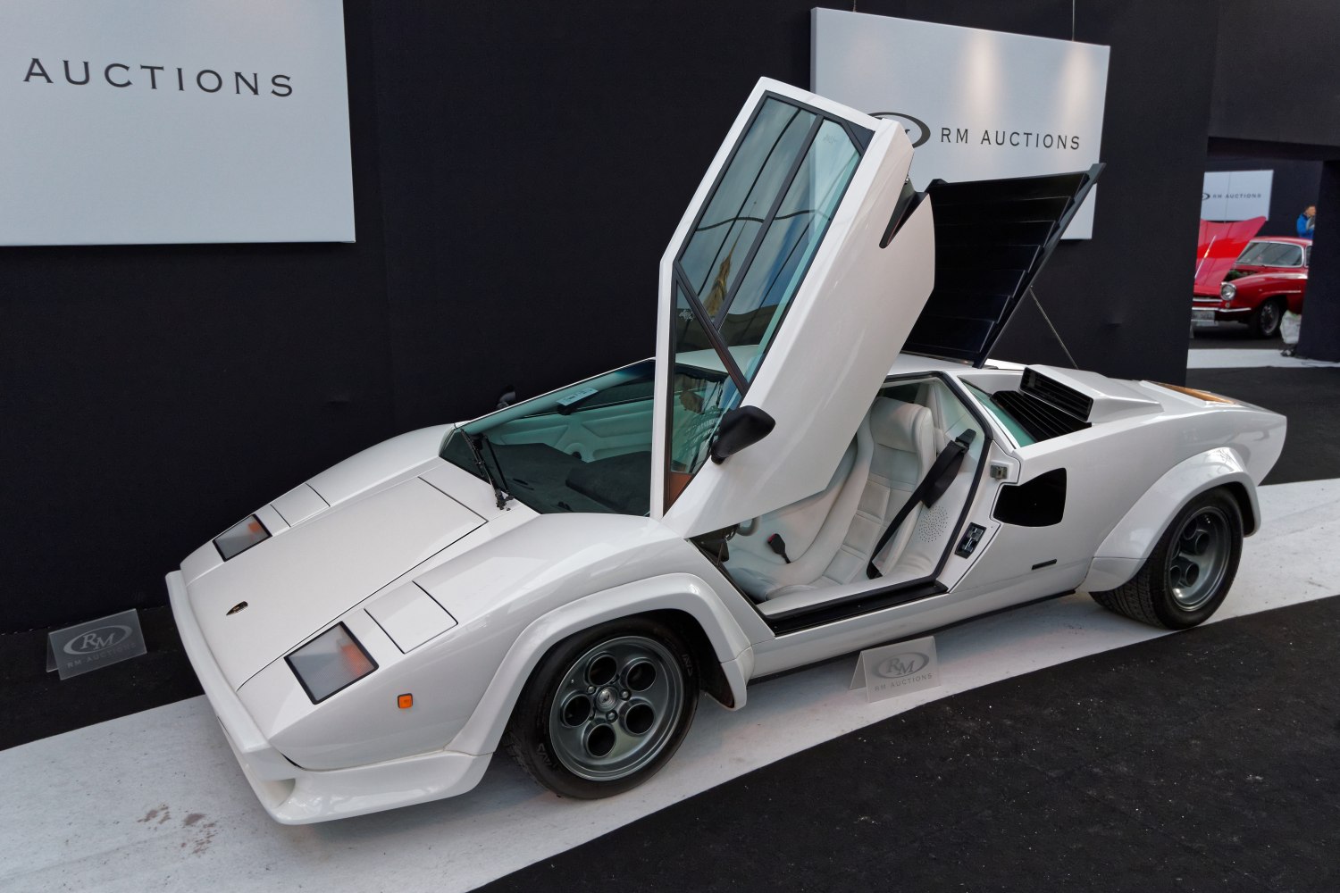 White Lamborghini with signature upward scissor doors and angular body styling