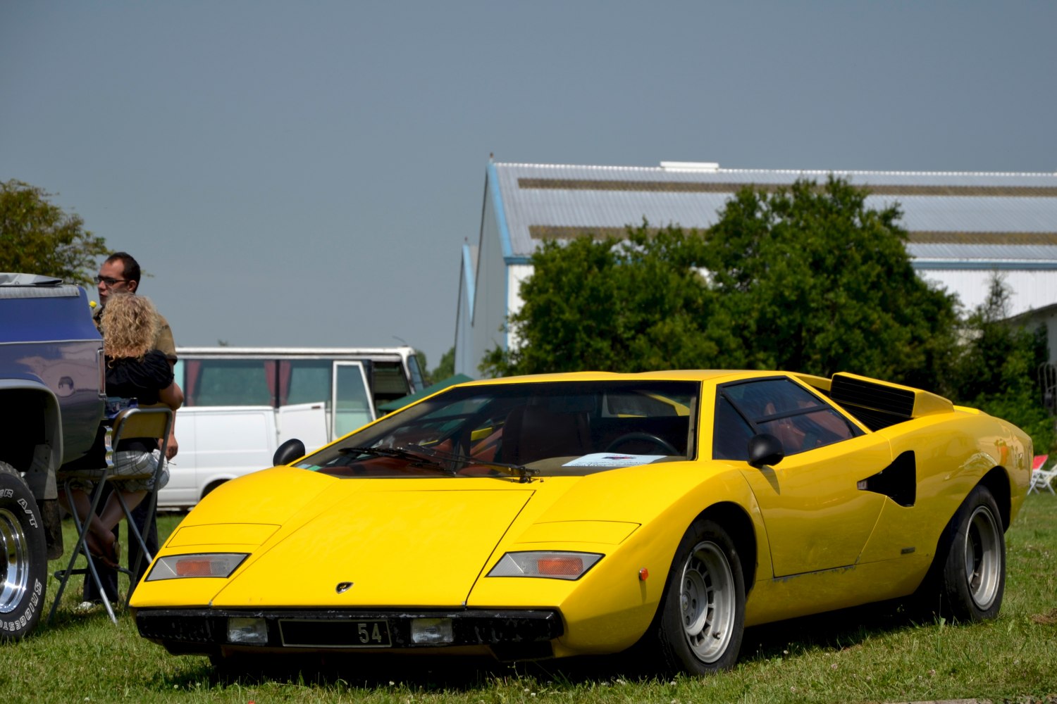Yellow wedge-shaped sports coupe with pop-up headlights and low profile.