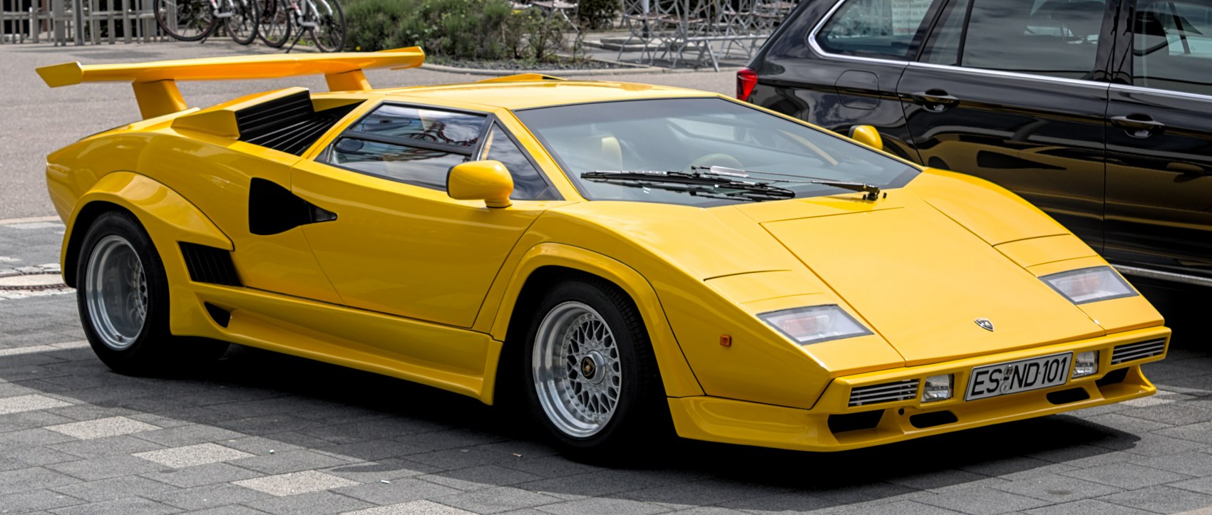 Angular yellow sports car with large rear wing and low profile design
