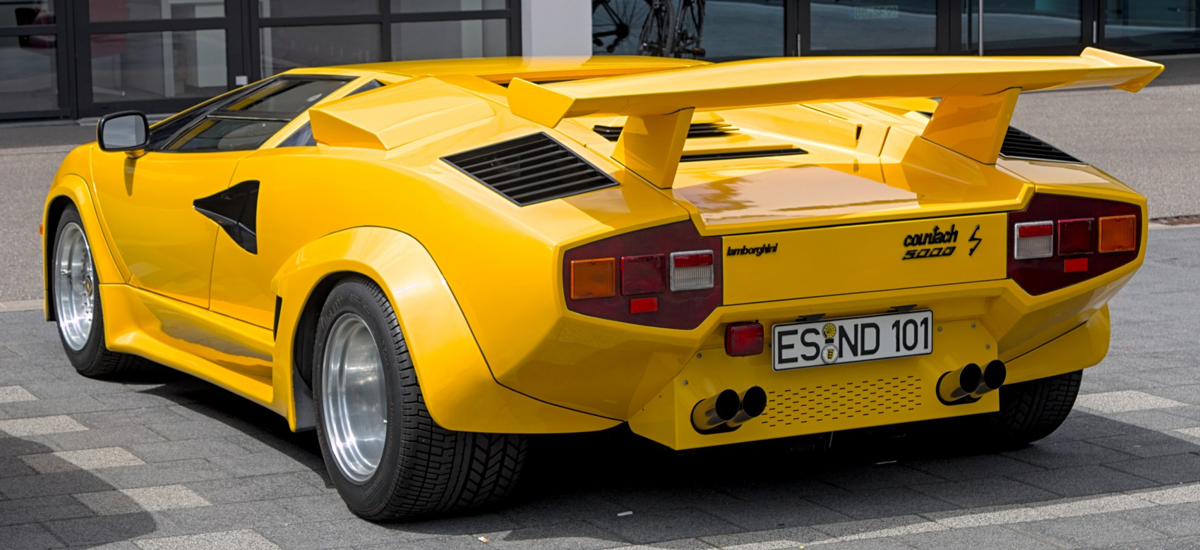 Yellow Lamborghini rear with large spoiler and angular taillights