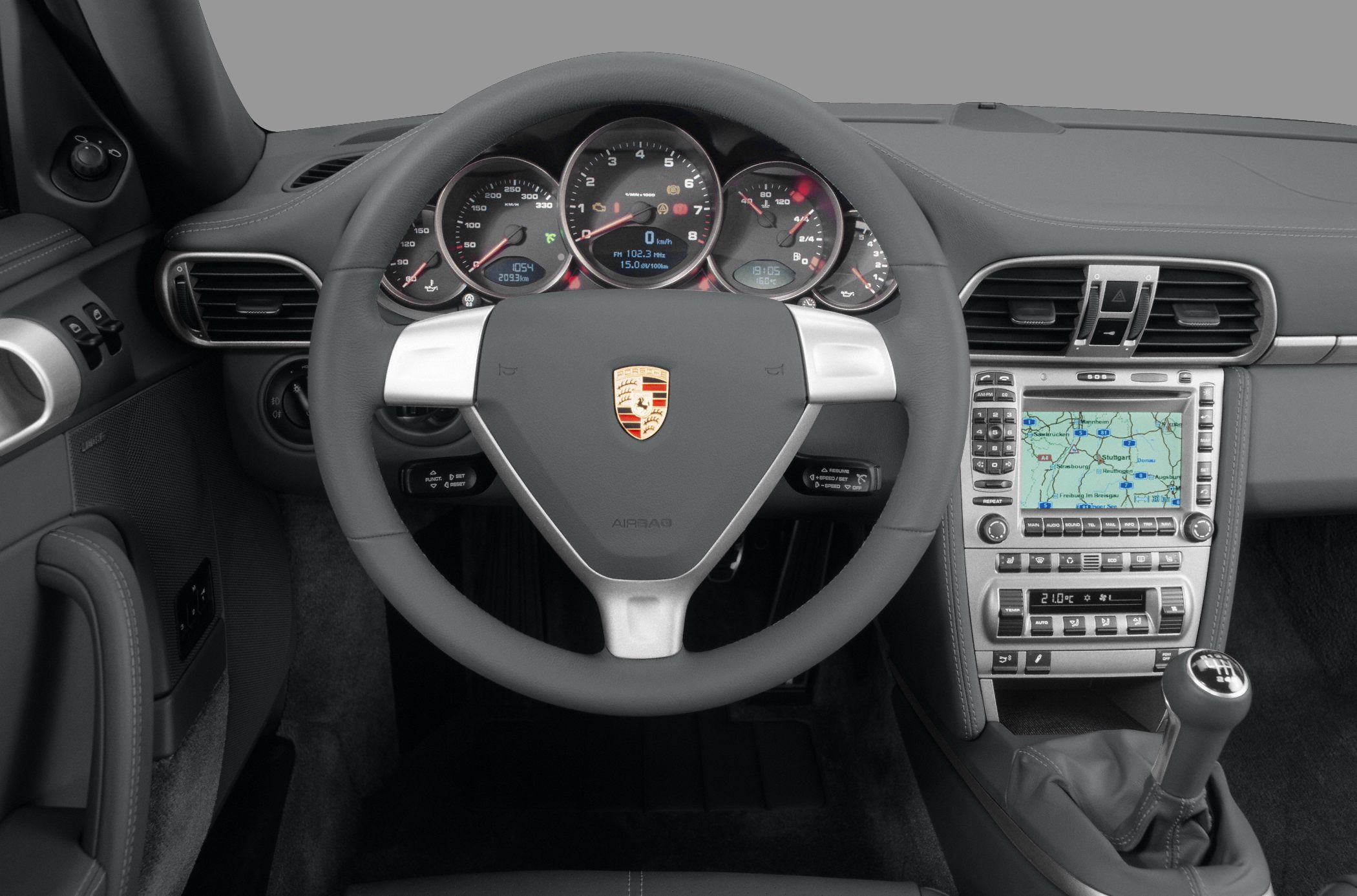 Dashboard with analog gauges, navigation screen, steering wheel, manual gearshift