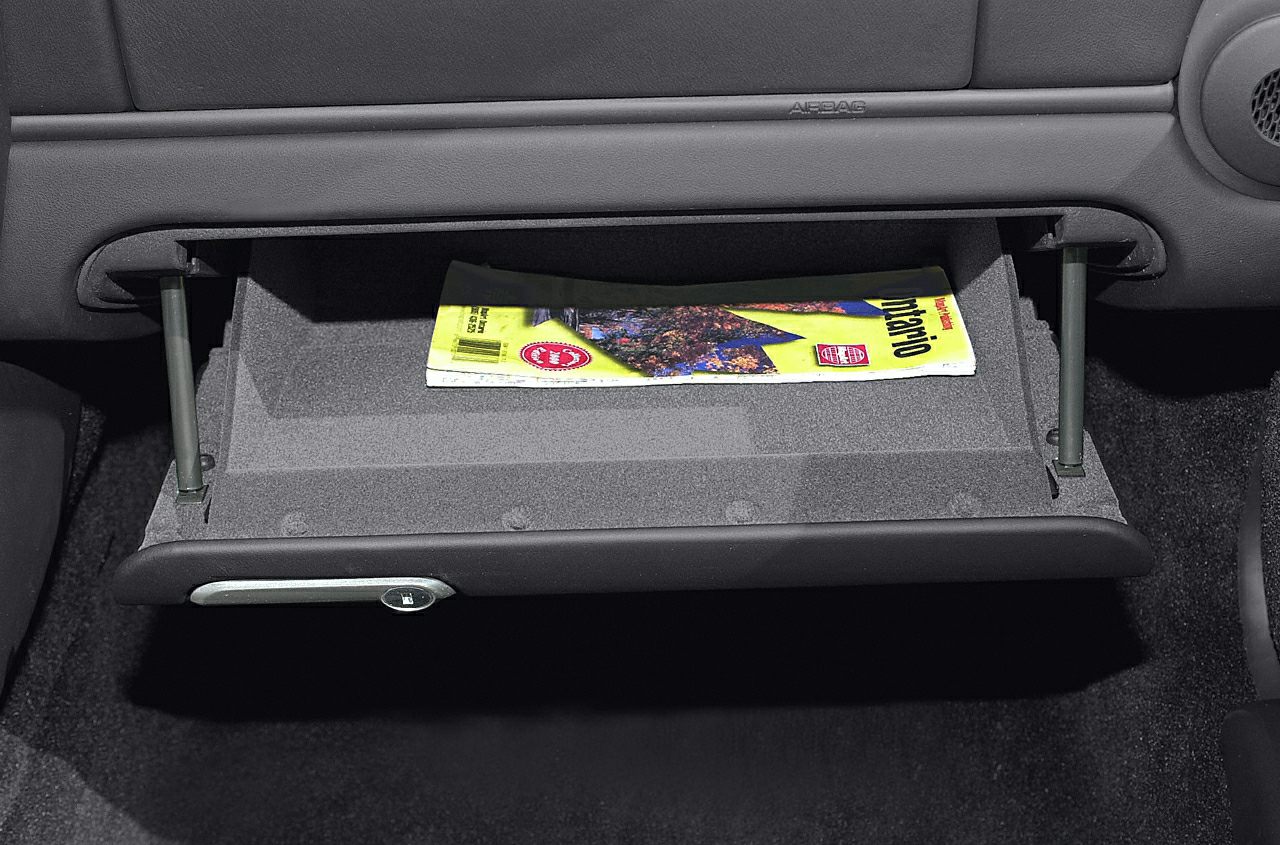 Open glovebox with magazine inside in car interior