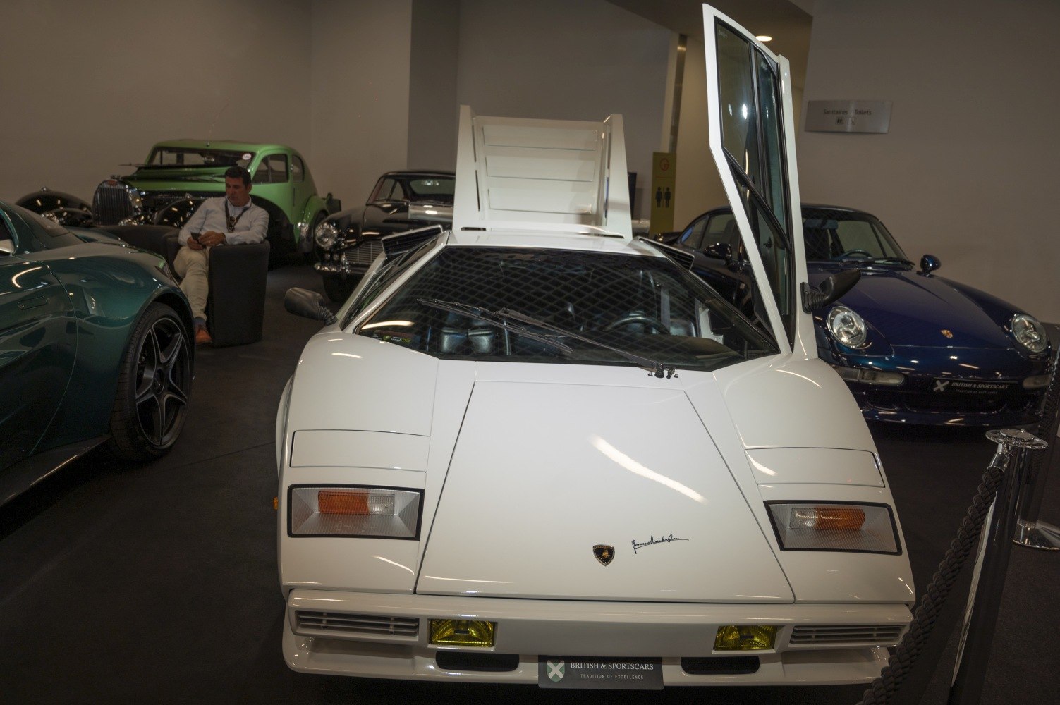 White Lamborghini with butterfly door open, angular front design.