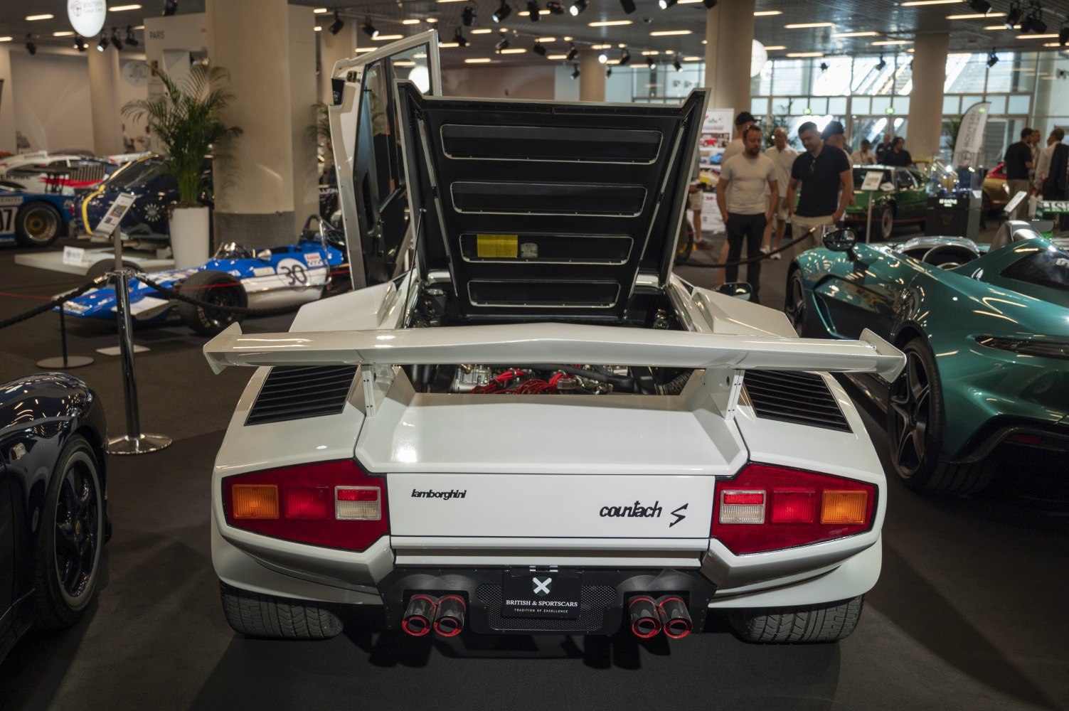 Rear view with open engine cover, rear spoiler, and quad exhausts