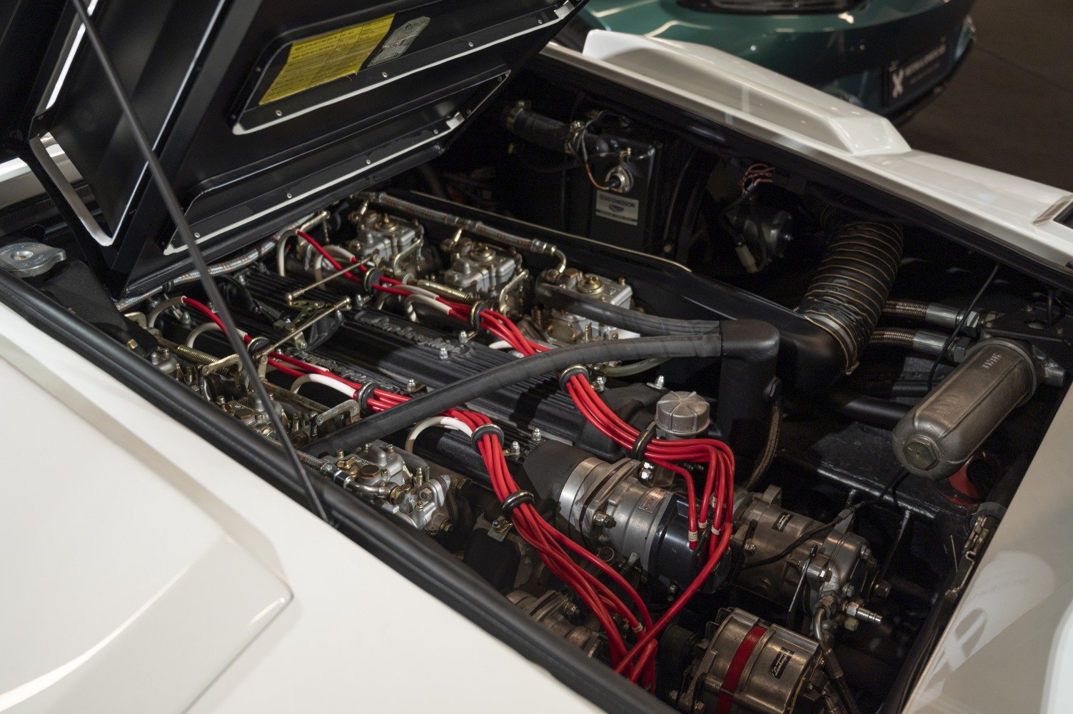 Close-up of classic engine with red ignition wires and mechanical parts