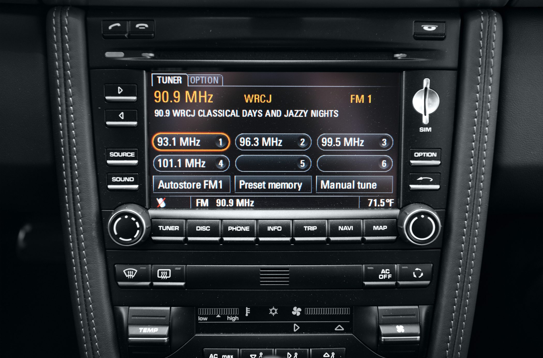 Car multimedia radio tuner and climate control interface with buttons and display.