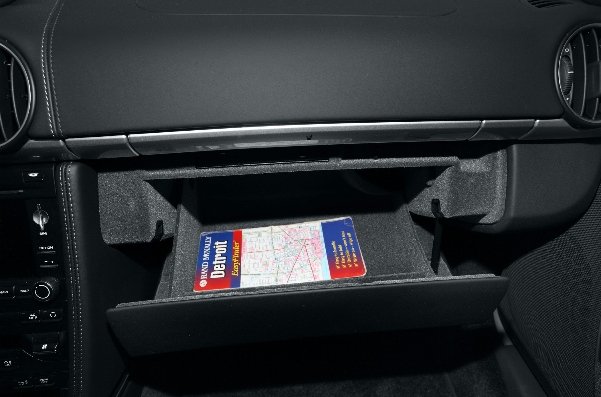 Glove box storage compartment with a road map inside.