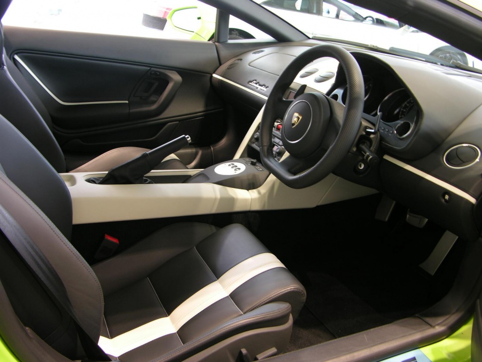 Modern luxury sports car interior with steering wheel, dashboard, and leather seats