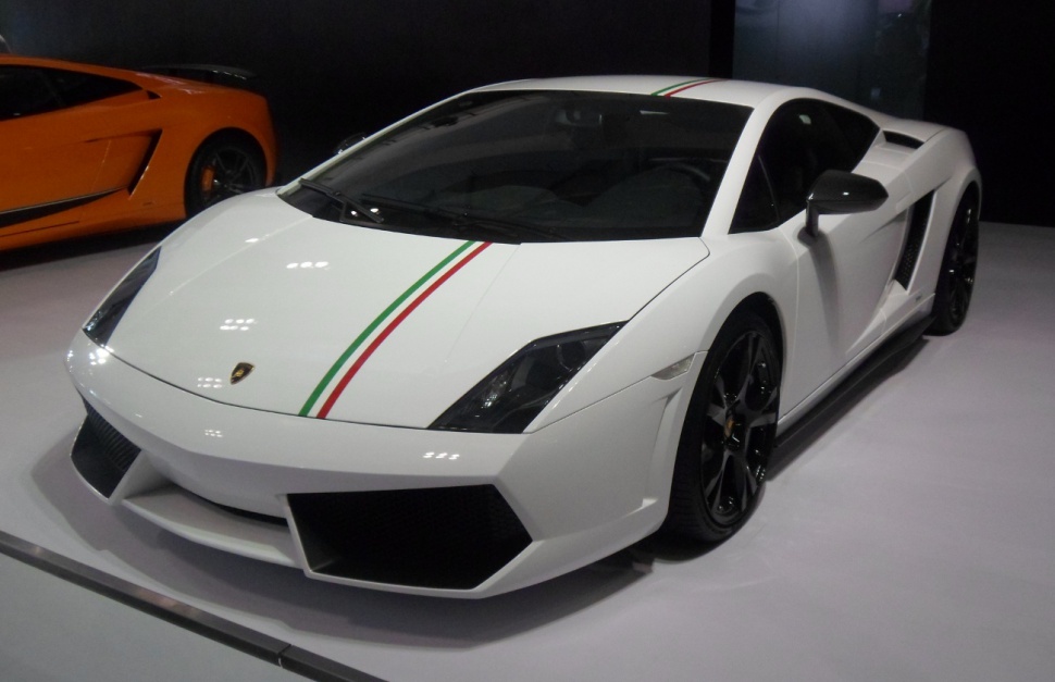 White Lamborghini Gallardo with racing stripe and black wheels front angled view