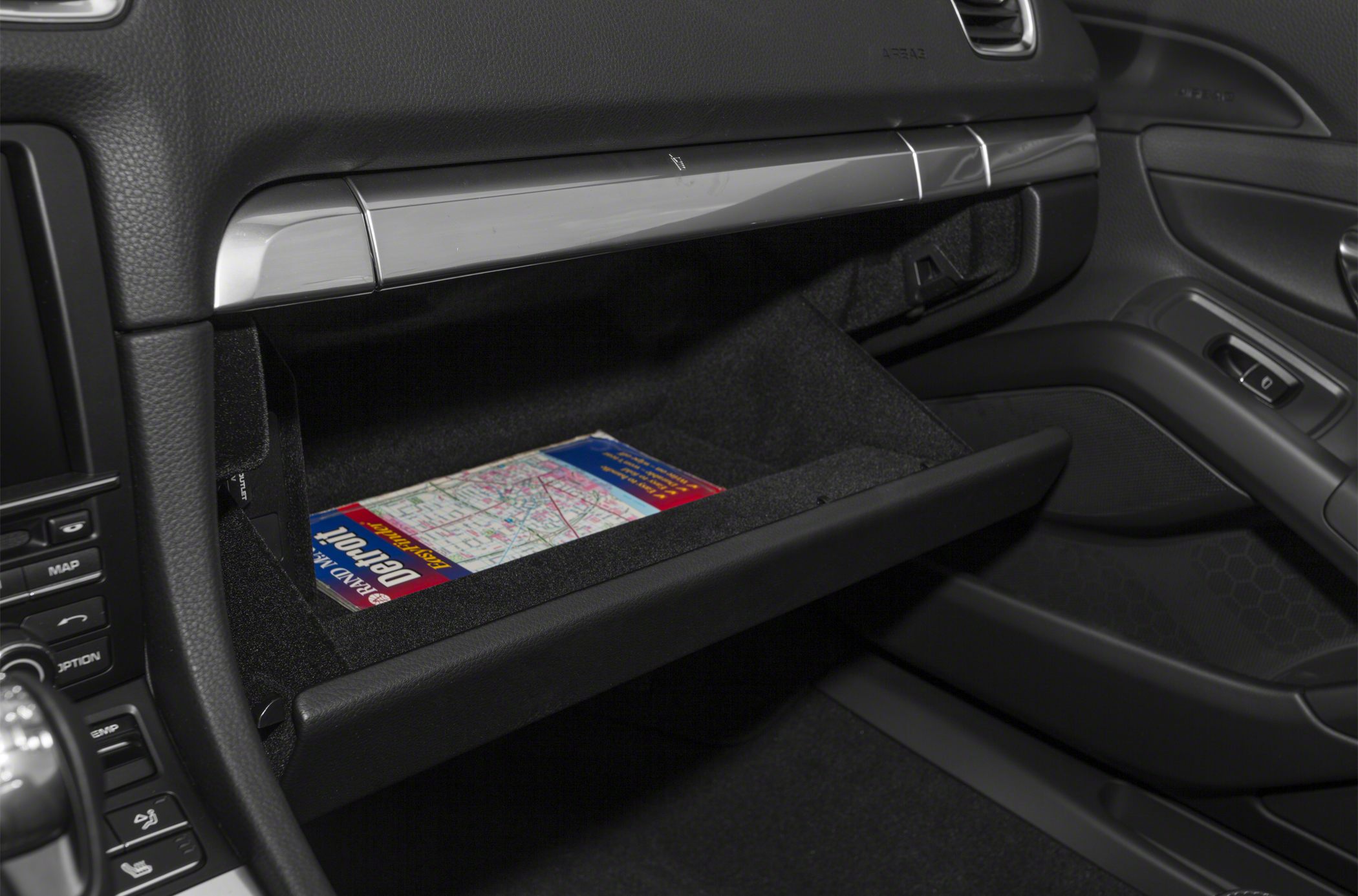 Open glove compartment with a map inside in a modern car interior