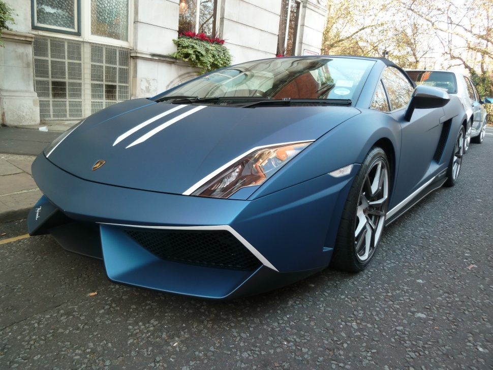 Front angled view of matte blue sports car with sharp headlights and aerodynamic front design