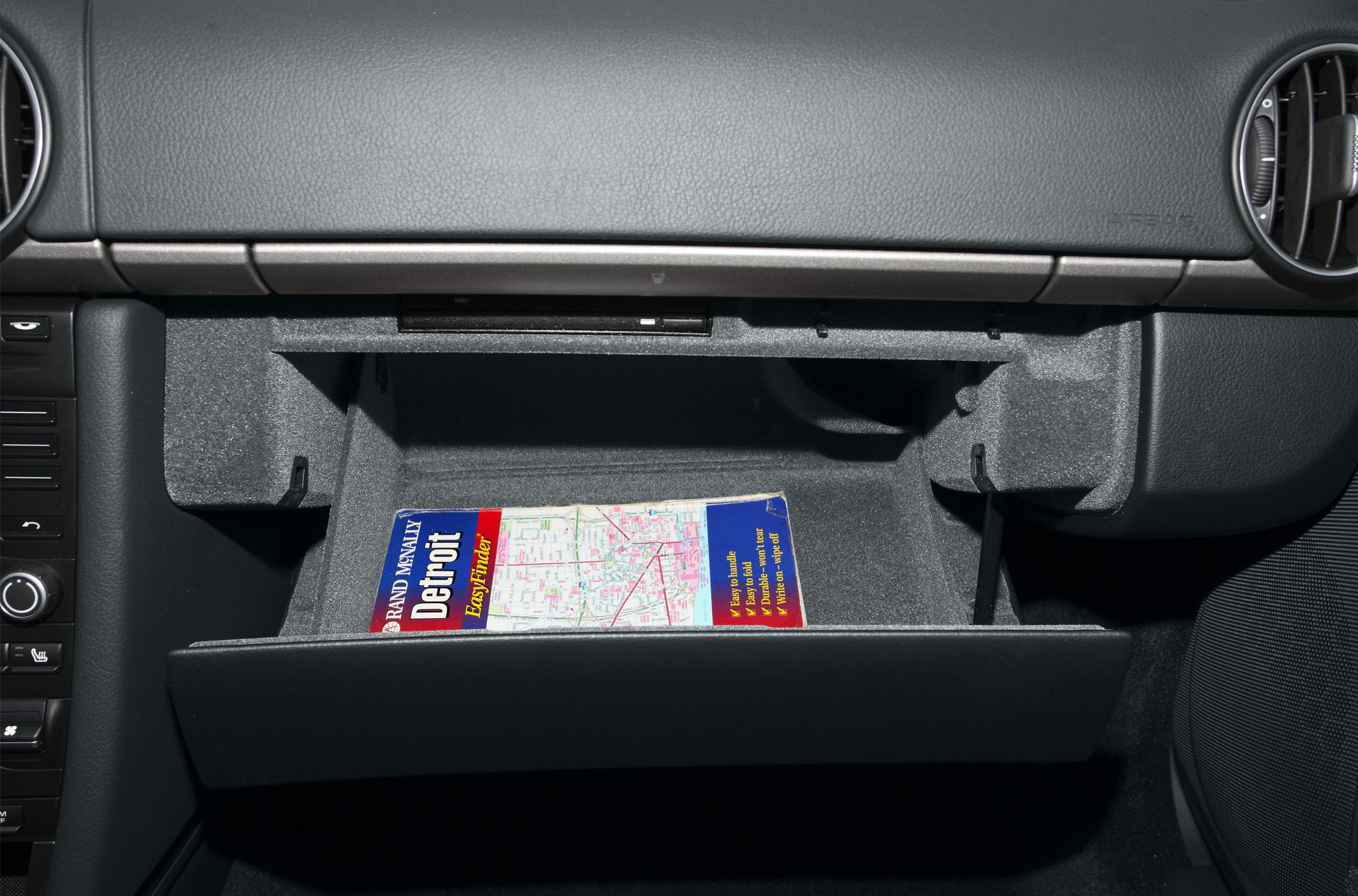 Open glove compartment with a Michigan map inside