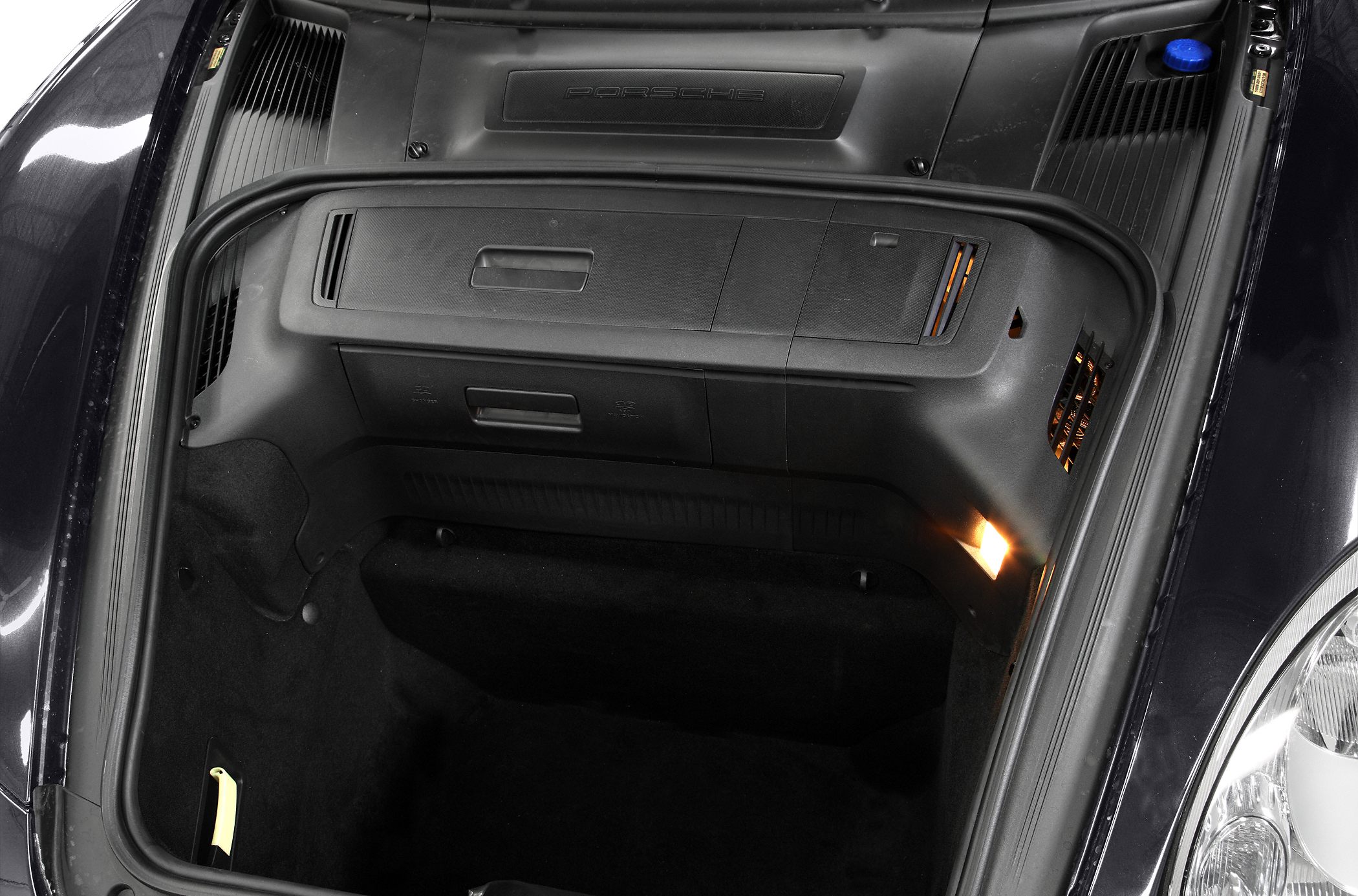 Front trunk storage compartment with interior lighting in a sports car