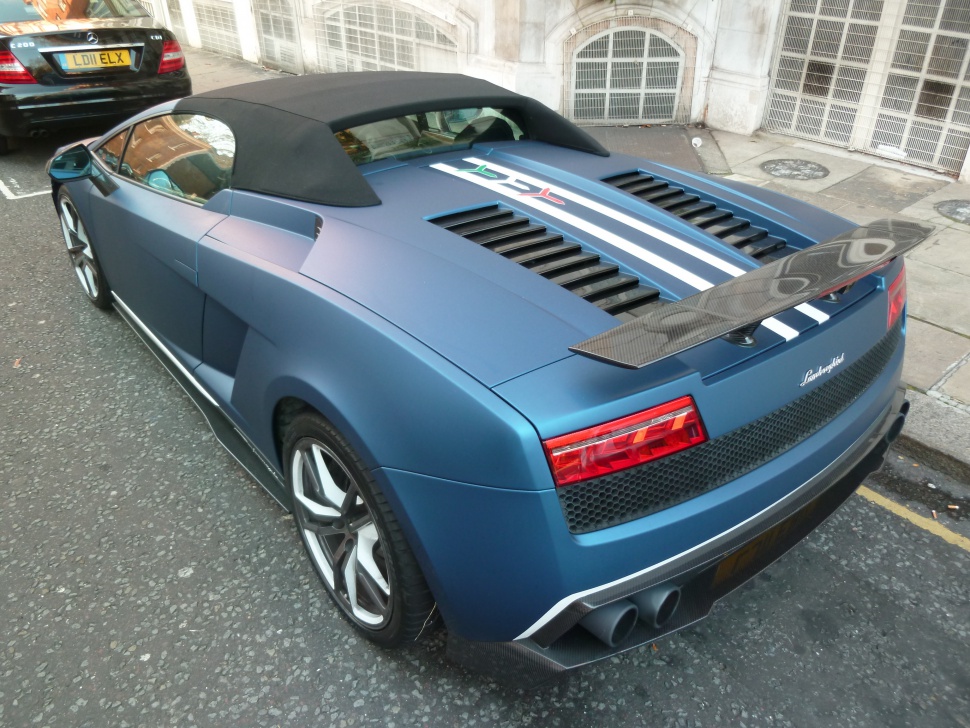 Rear carbon fiber spoiler and soft convertible roof of a sports luxury car