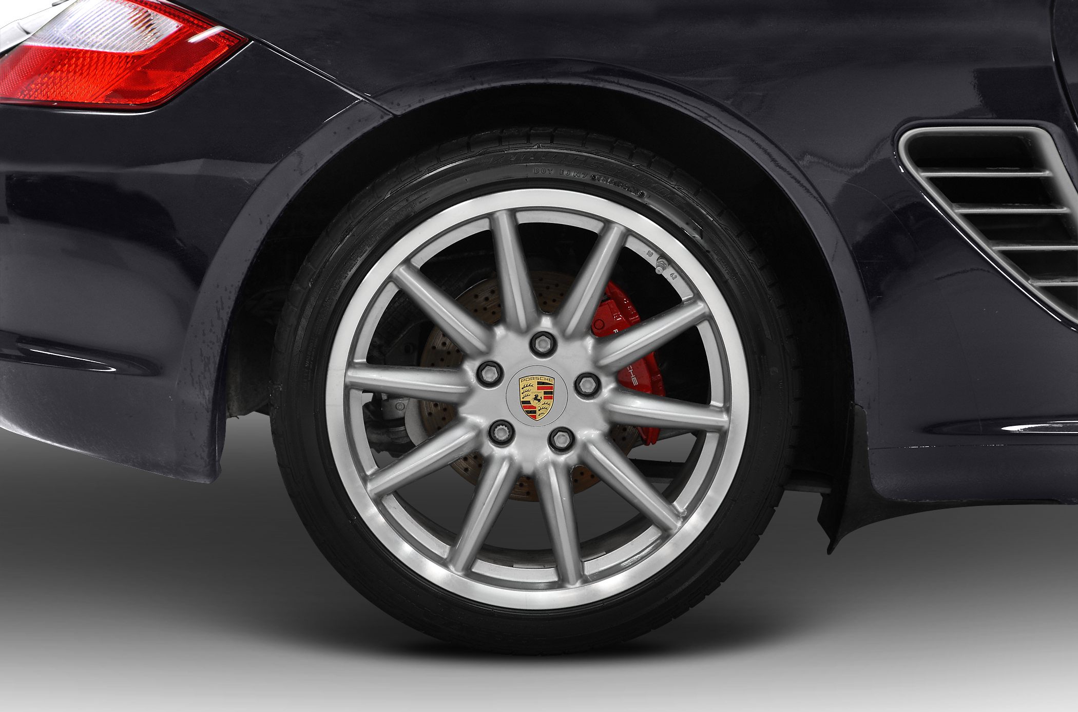 Alloy wheel with red brake caliper and rear fender air vent