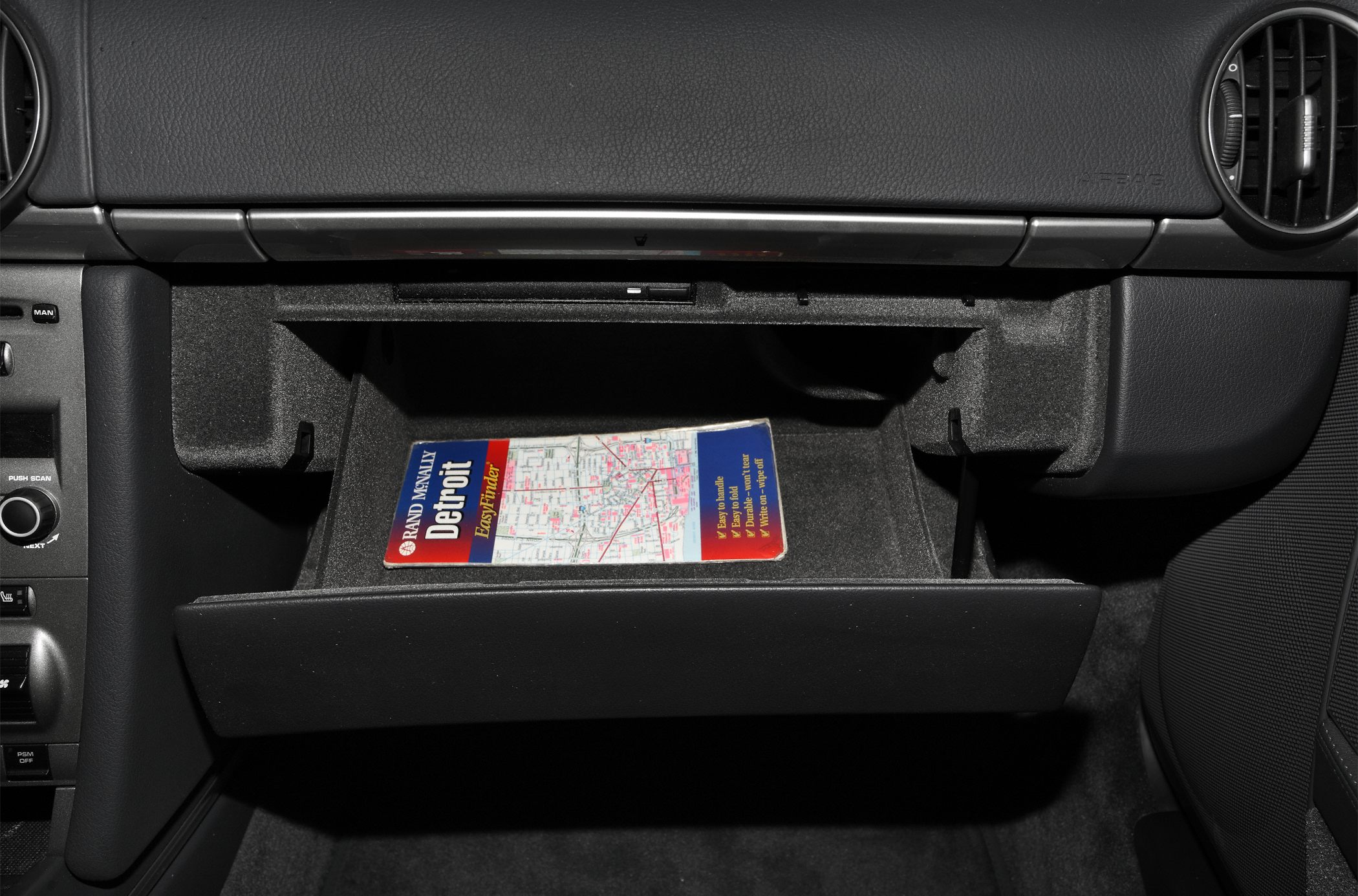 Open glovebox compartment with map inside