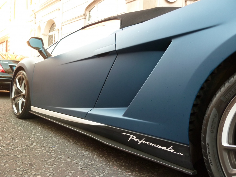 Side air intake and 'Performante' badge on matte blue sports car body