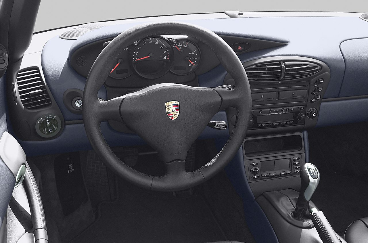 Dashboard and interior with steering wheel, analog gauges, and manual gearshift.