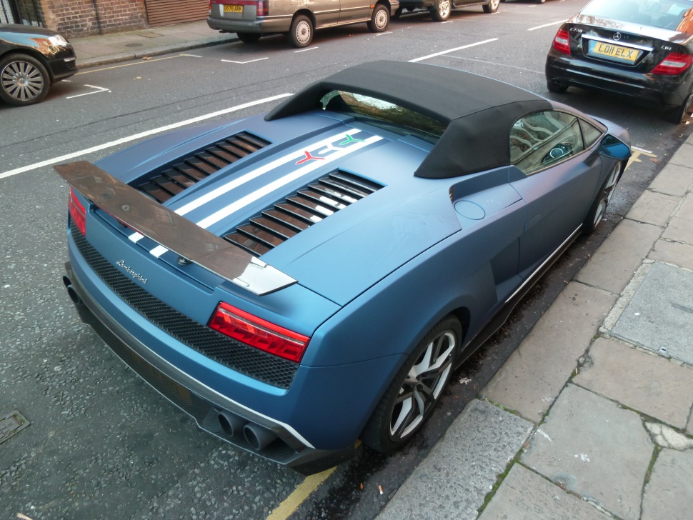 Rear convertible sports car with large rear wing and engine vents