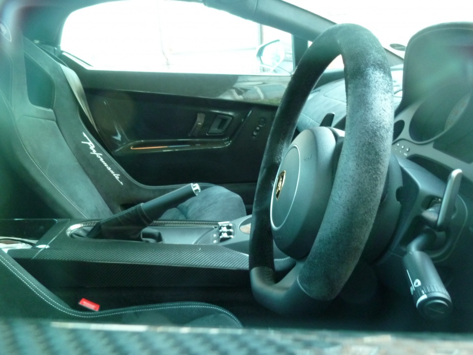 Suede steering wheel and racing bucket seat inside a sports car