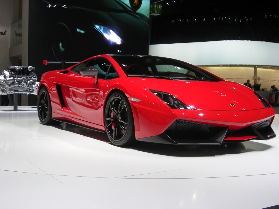 Red sports car with rear wing and black alloy wheels