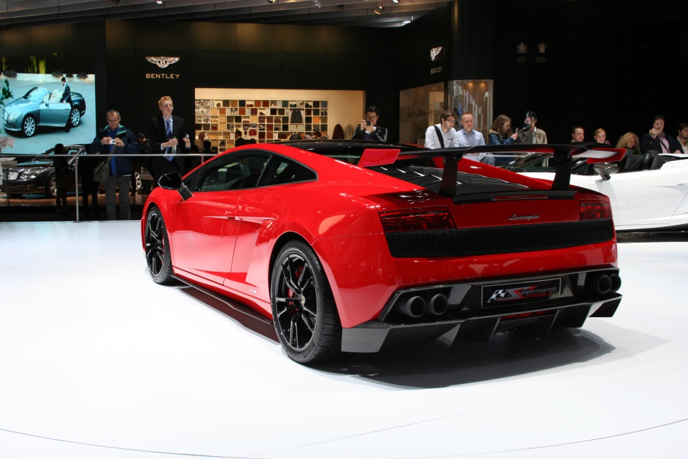 Rear of red sports car with large spoiler and quad exhausts