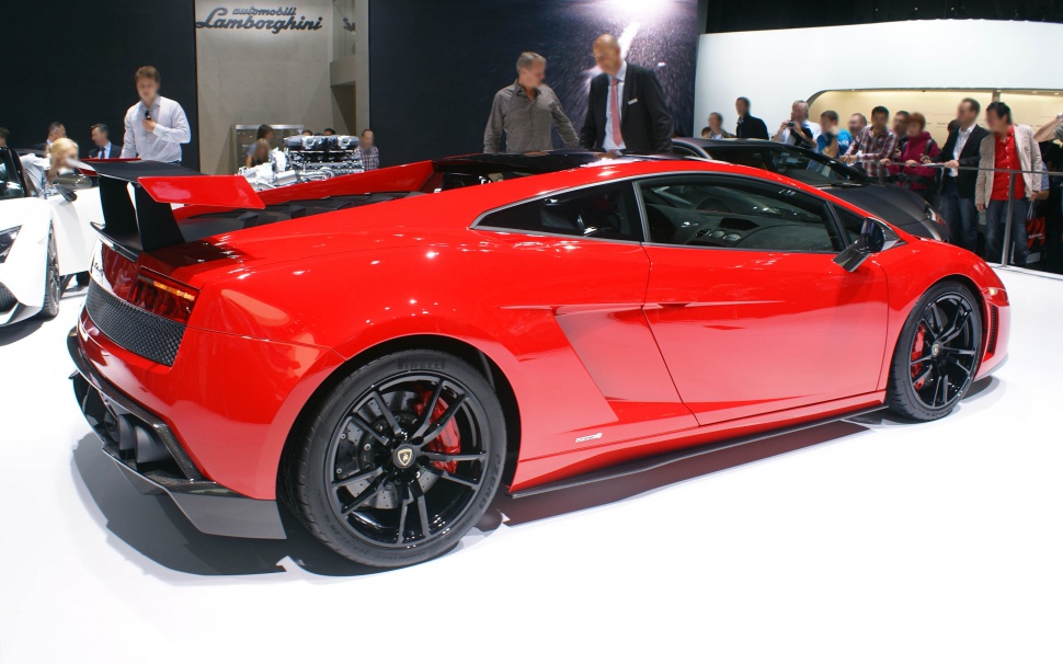 Red sports car with large rear wing and black aerodynamic wheels