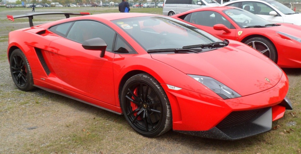 Red sports coupe with black wheels and prominent rear wing