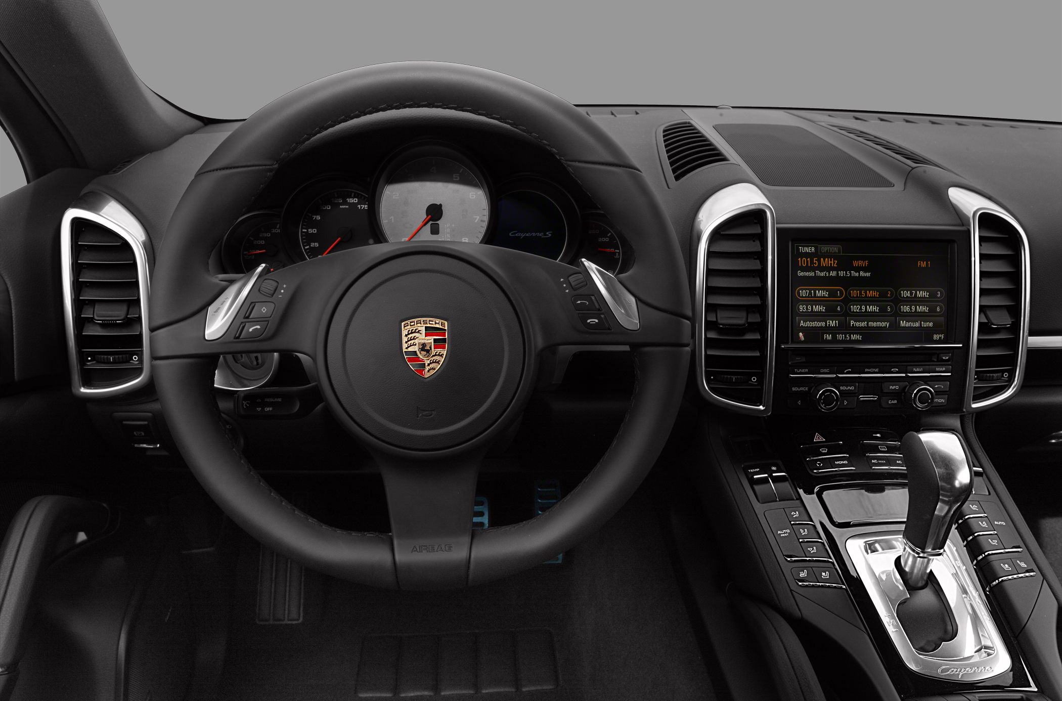 Interior steering wheel, instrument cluster, and center console with gear selector.