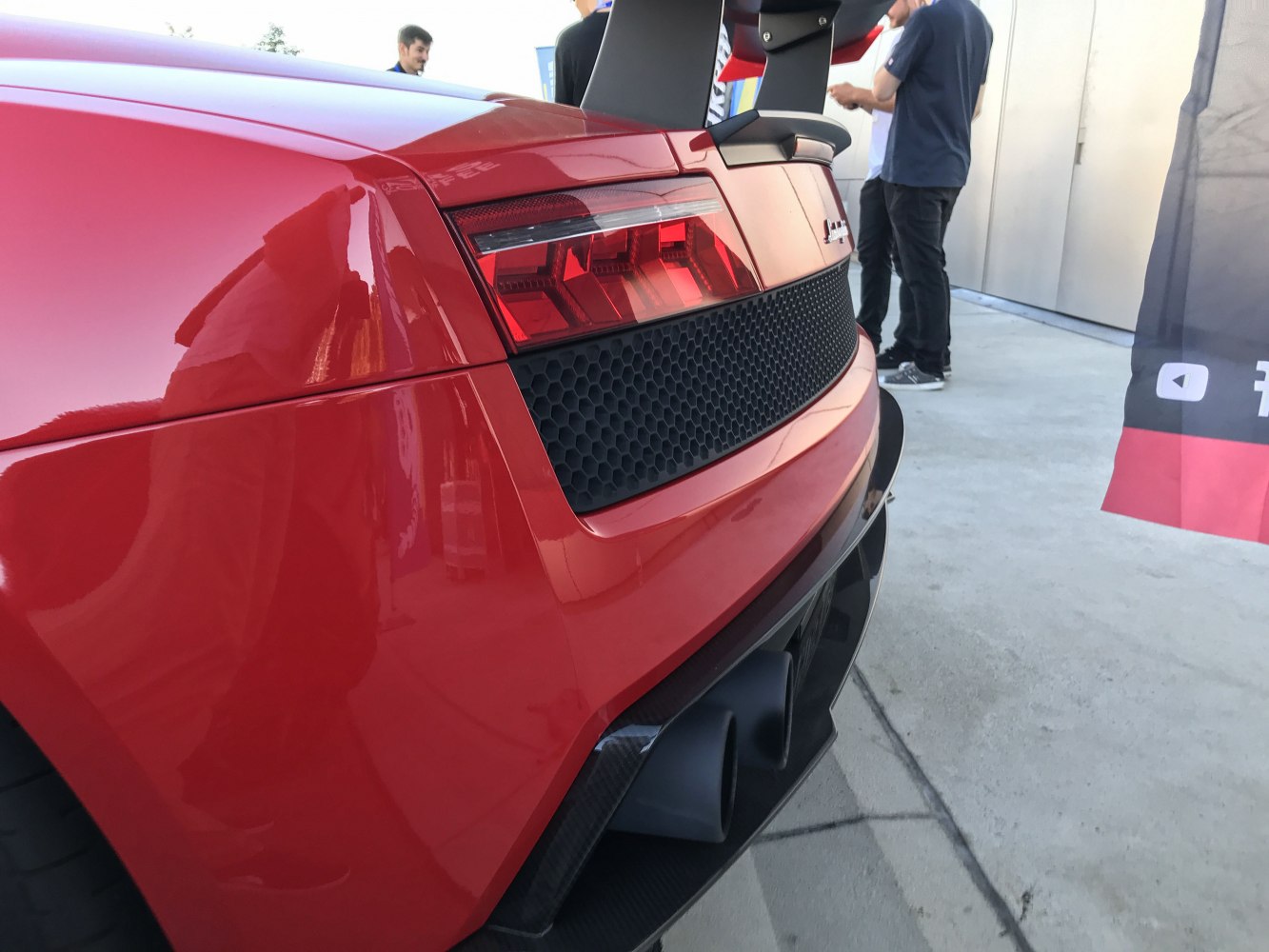 Close-up of rear tail light and twin exhaust with honeycomb grille.