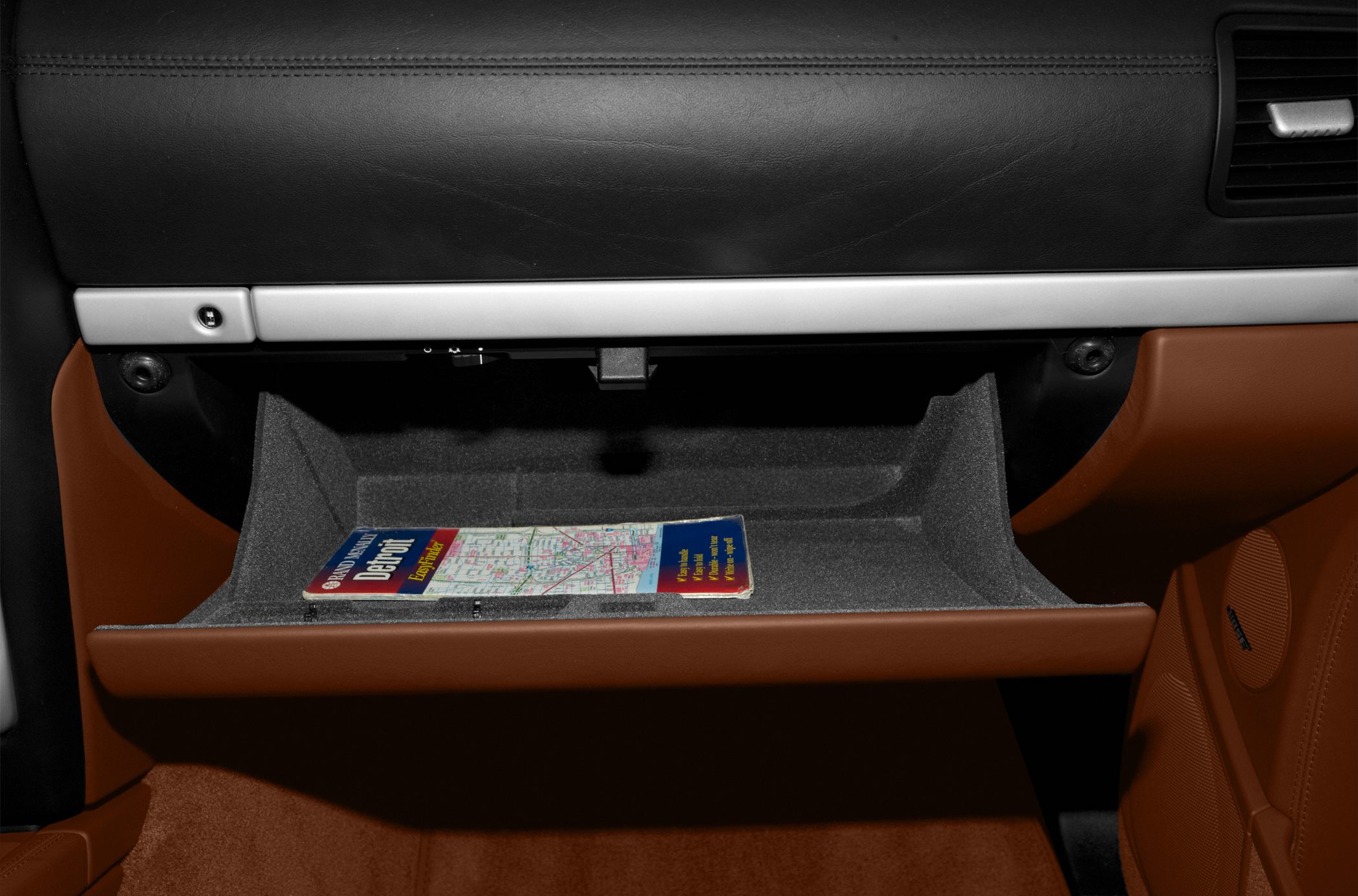 Glove compartment interior with map and brown leather trim