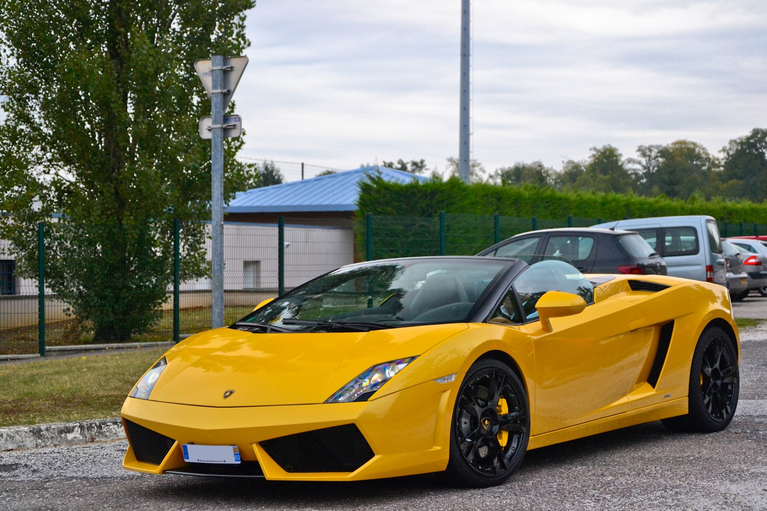 Yellow spyder convertible with black wheels front-side view