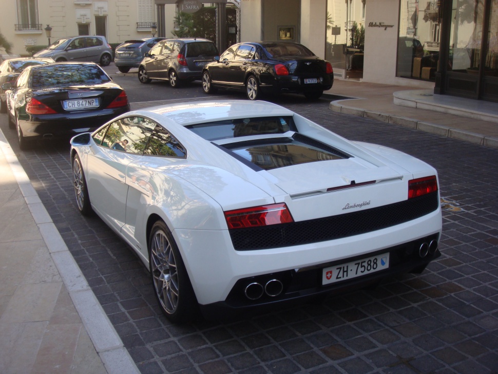 Rear view of white Lamborghini Gallardo with quad exhaust and taillights.
