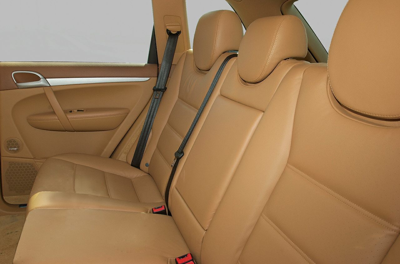 Tan leather rear seats with headrests and seatbelts in SUV interior