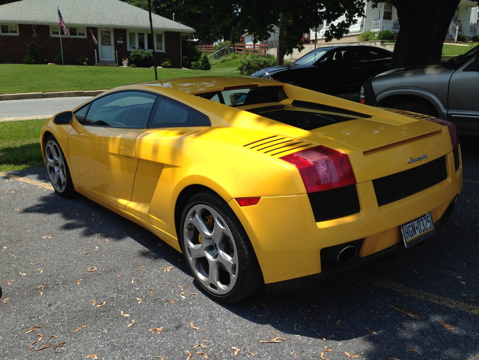 Yellow sports coupe rear side with angular taillights and alloy wheels