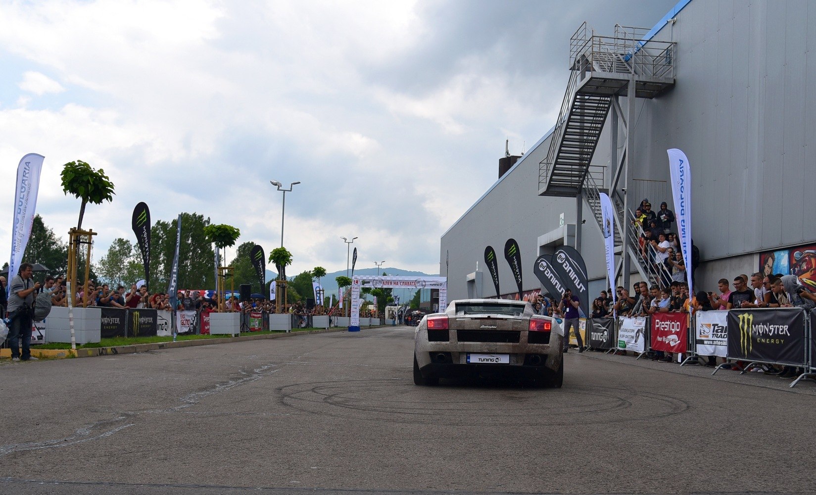 Wide rear view of a sports coupe with distinct taillights on an event track
