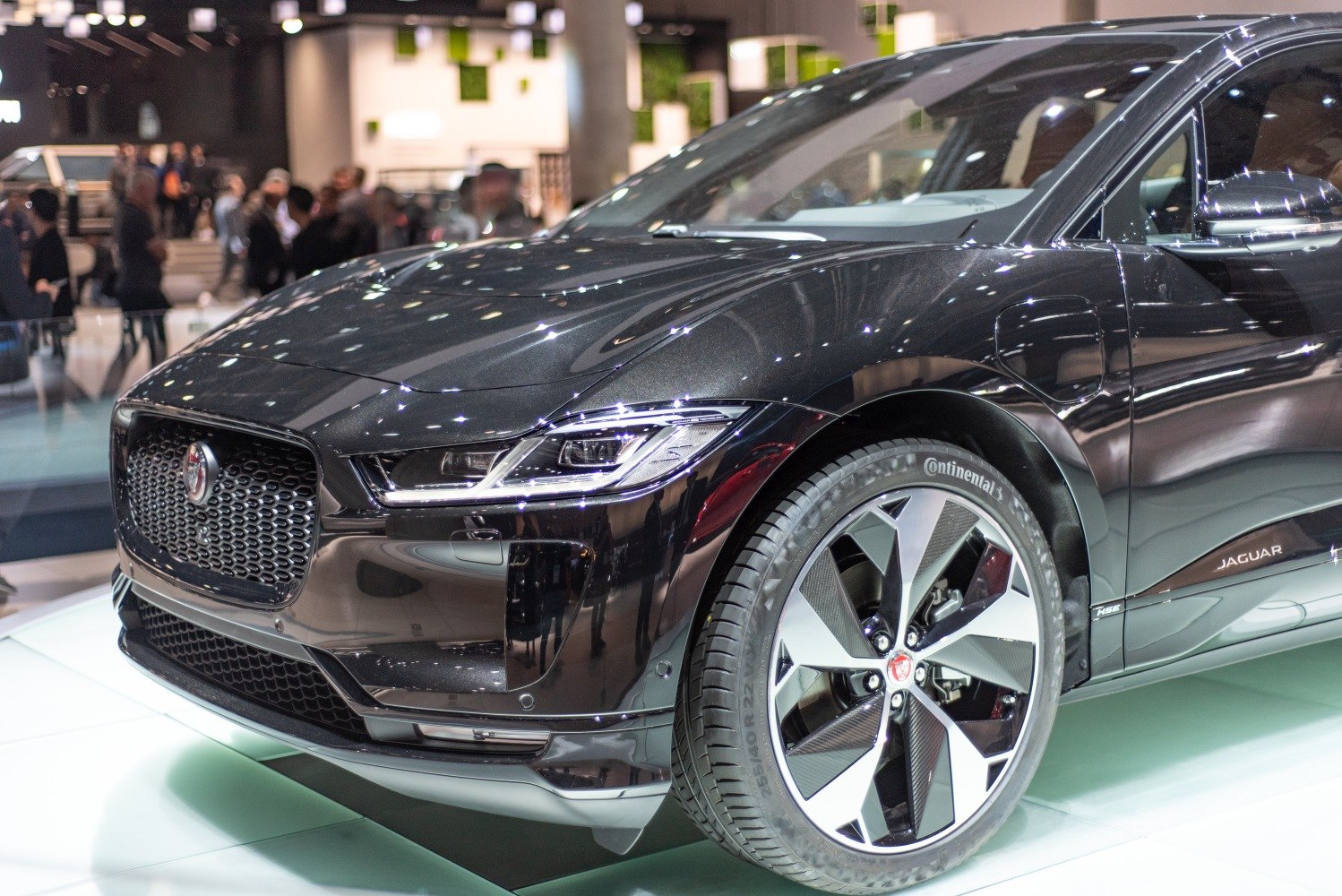 Close-up of front grille, headlight, and alloy wheel design.