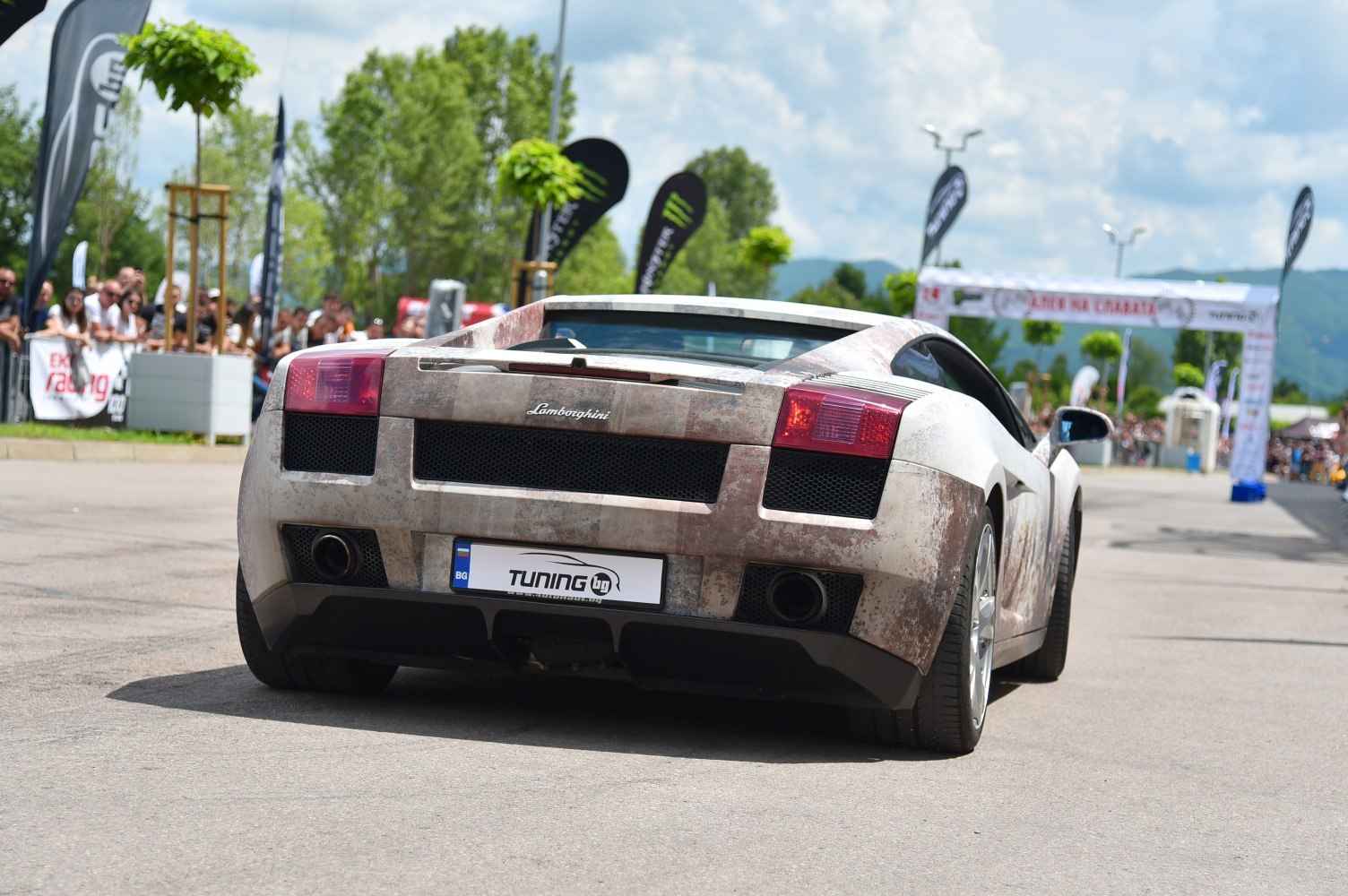 Rear of sports car with rust-effect wrap and dual exhaust pipes