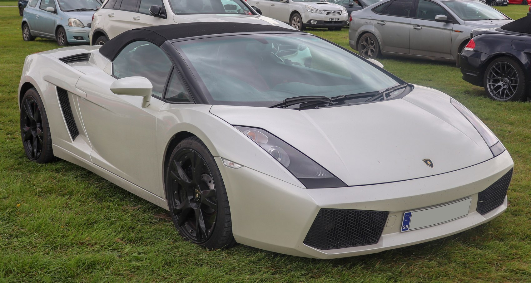Front and side view of white convertible with black soft top and angular design