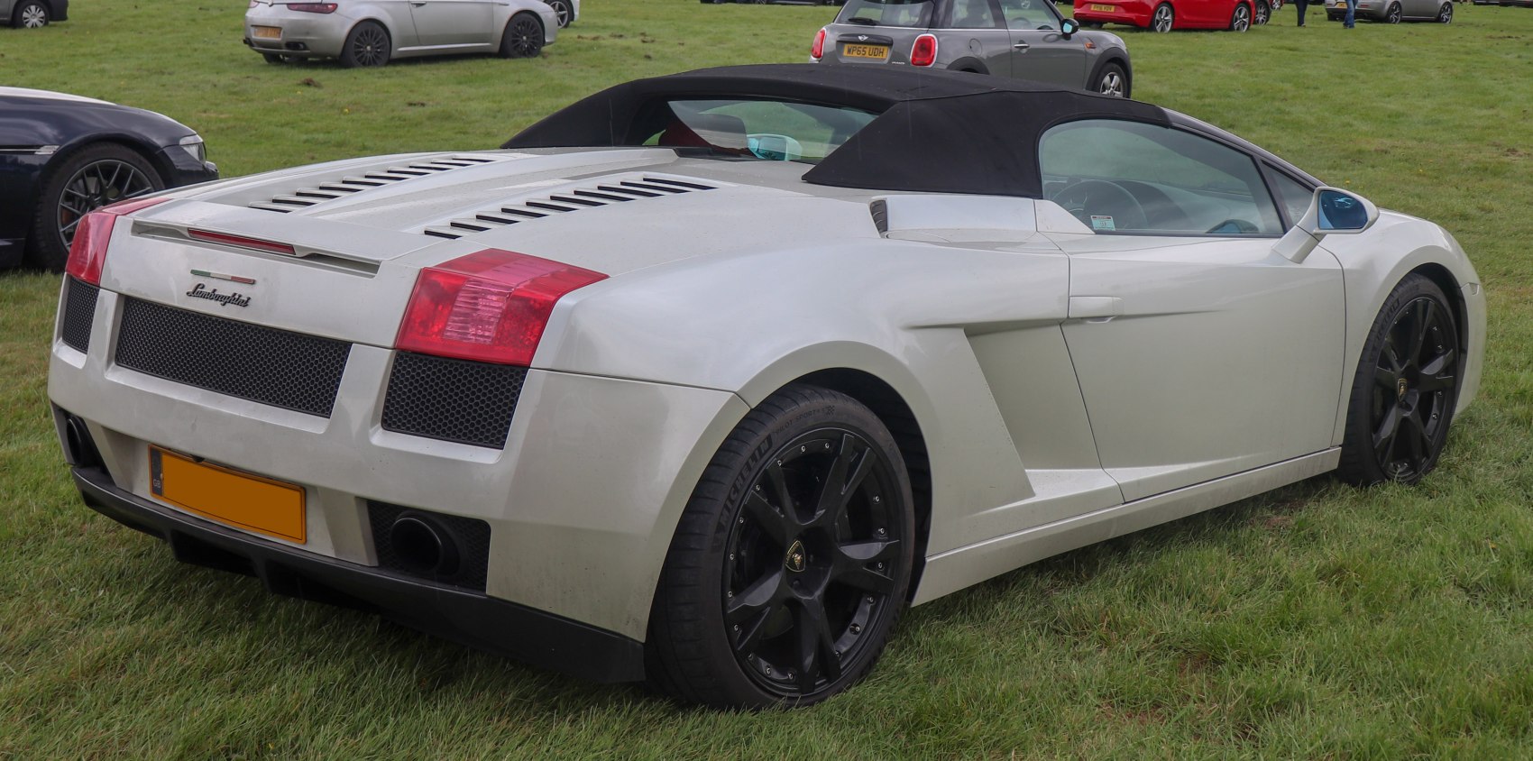 Rear side view of convertible with black wheels and soft top