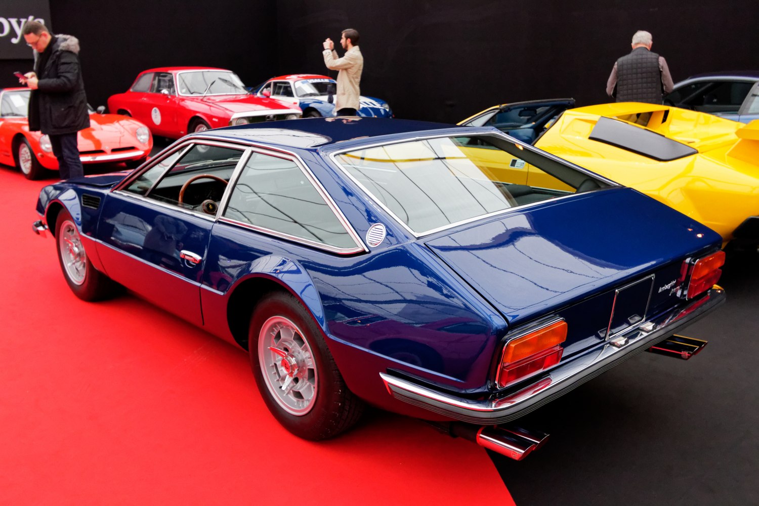 Sleek rear and side profile of a vintage coupe with chrome trim and sporty wheel design.