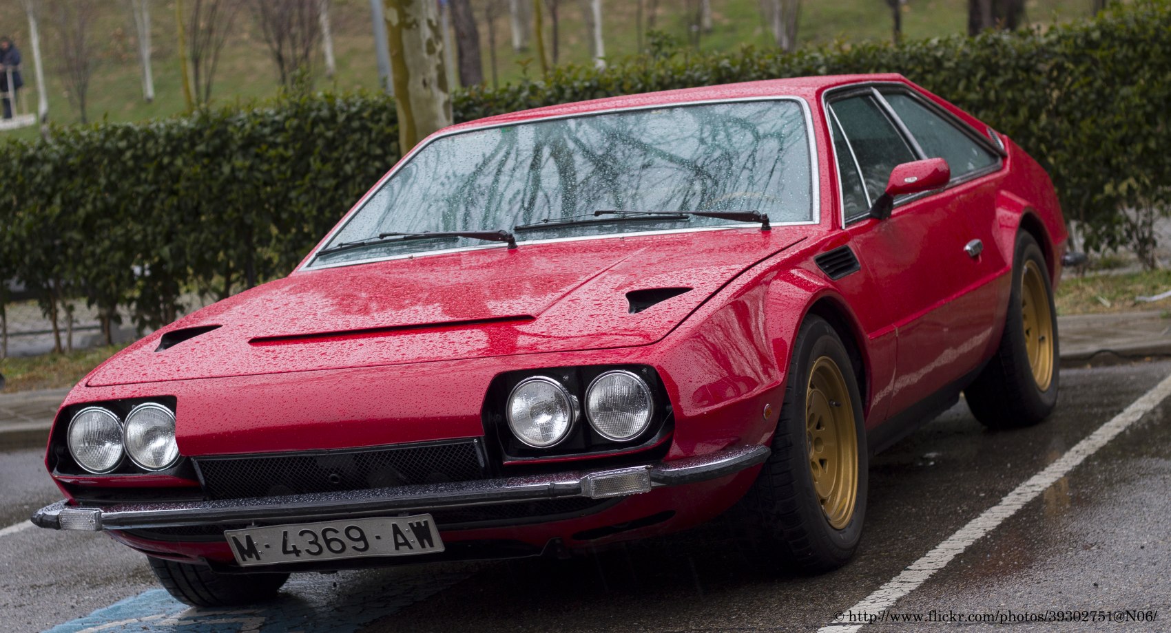 Vintage sports coupe with quad headlights and gold wheels