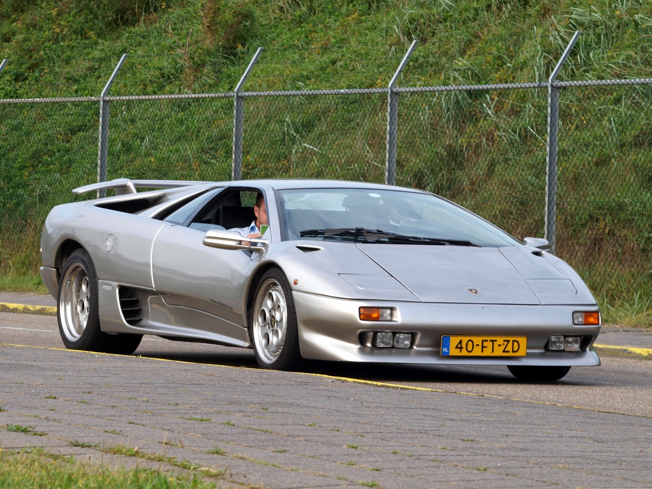 Silver exotic coupe with rear wing and side air vents
