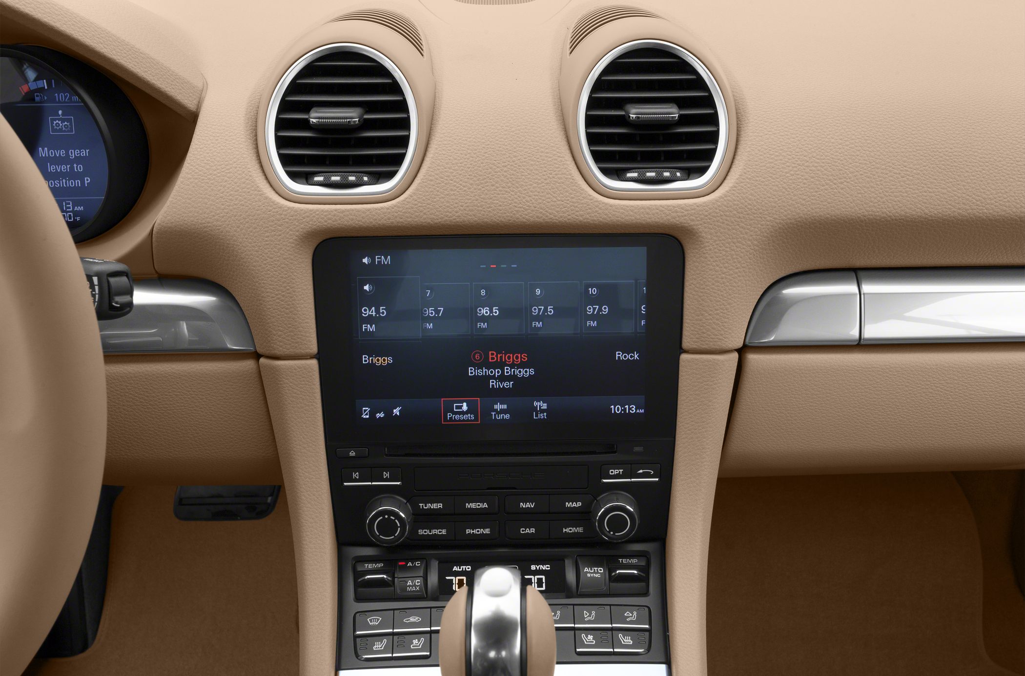 Center console with infotainment screen and climate control buttons in beige interior