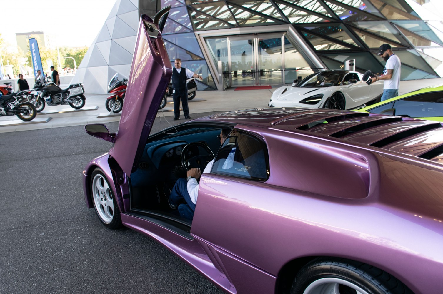 Purple sports car with distinctive scissor door open