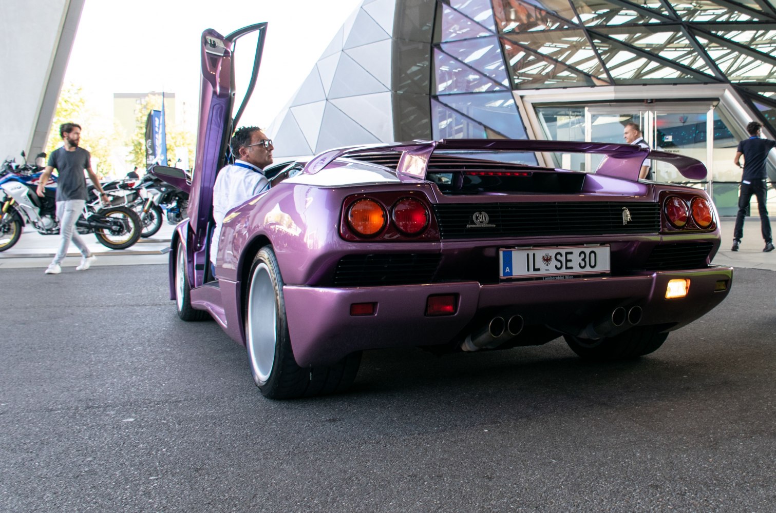 Purple rear view with open scissor door and rear wing