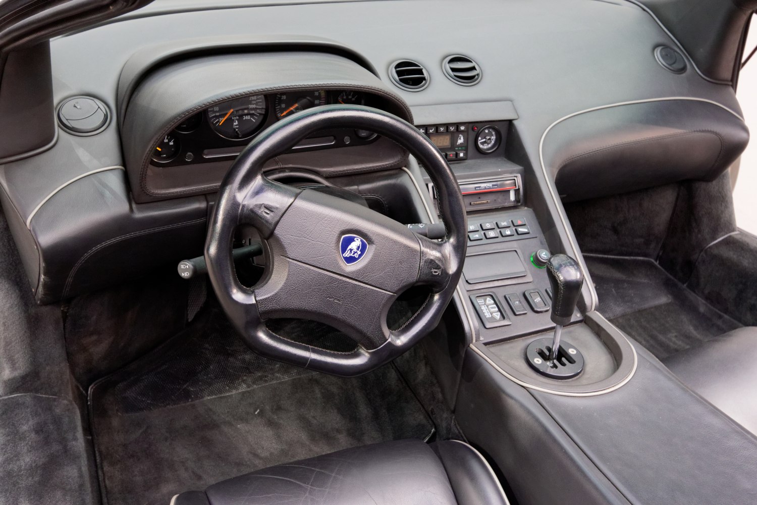 Leather steering wheel with Lamborghini emblem and gated manual shifter